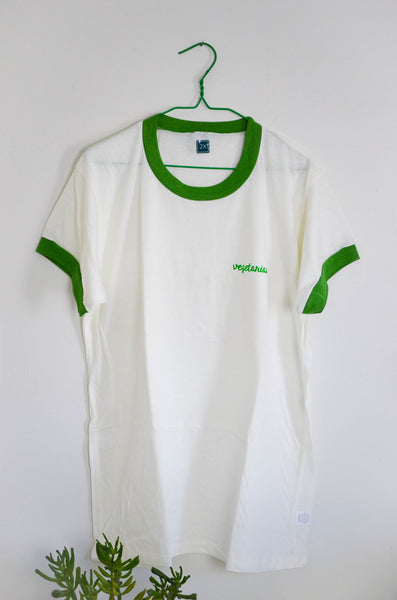 White t-shirt with green accents on a hanger against a white background
